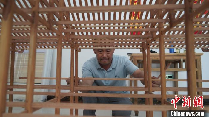 刘安喜制作吊脚楼模型 张宝训 摄
