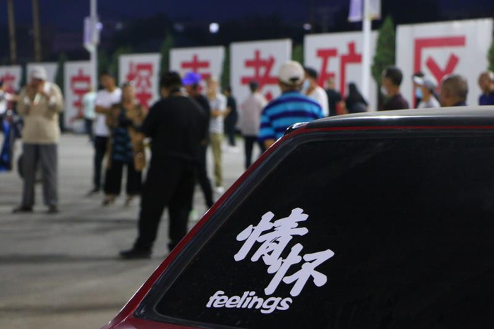  9月4日，夜幕降临，有人在新邱区工人文化宫广场吹奏乐器，一群人围着看。新京报记者杜寒三摄