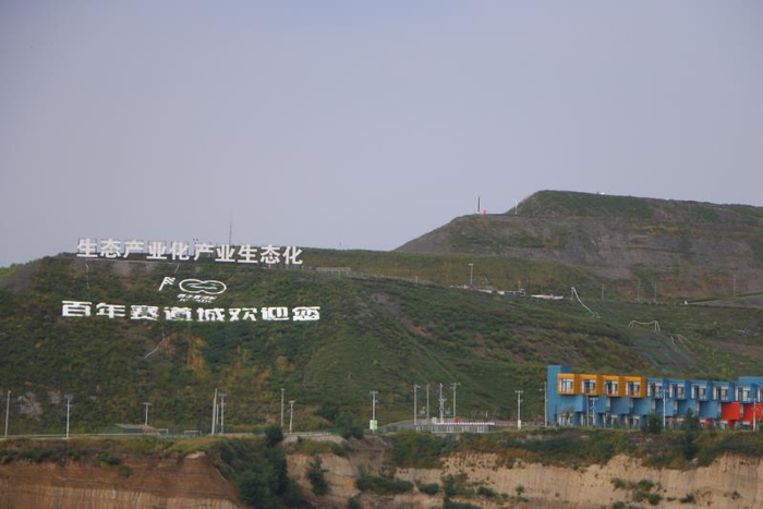  9月5日，阜新百年国际赛道城，山头上立着“生态产业化，产业生态化”的标语。新京报记者杜寒三摄