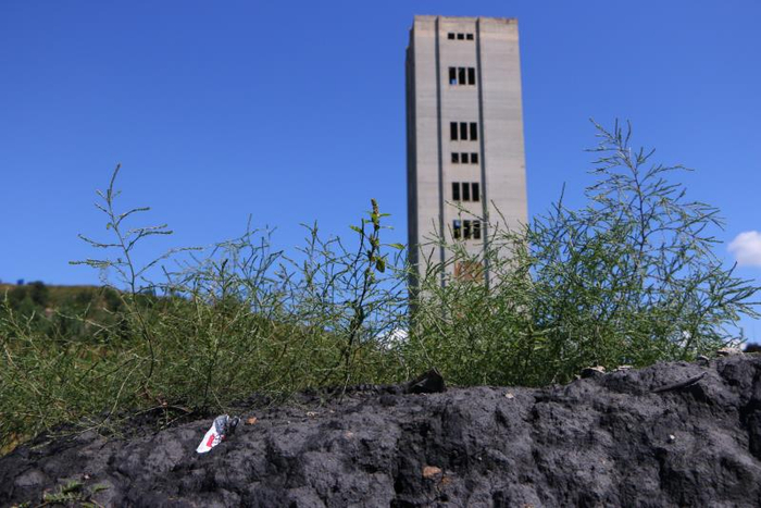  9月7日，阜新郊区一处废弃的竖井，围墙外堆着煤炭。新京报记者杜寒三摄