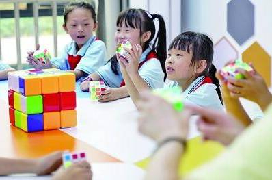 在重庆北碚区水土街道两江云顶小学，孩子们在老师的指导下玩魔方。新华社发