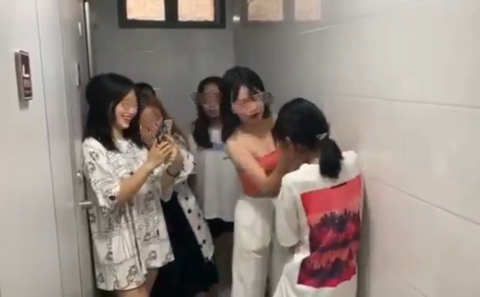 8月中旬，网传的欺凌视频中，穿粉色吊带的王茜用力掌掴朱锐锐，周围的女生笑着围观和录视频。视频截图