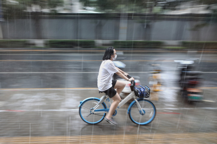 2021年8月，北京突降阵雨，一女士淋雨骑行。新京报记者 王嘉宁 摄&nbsp;