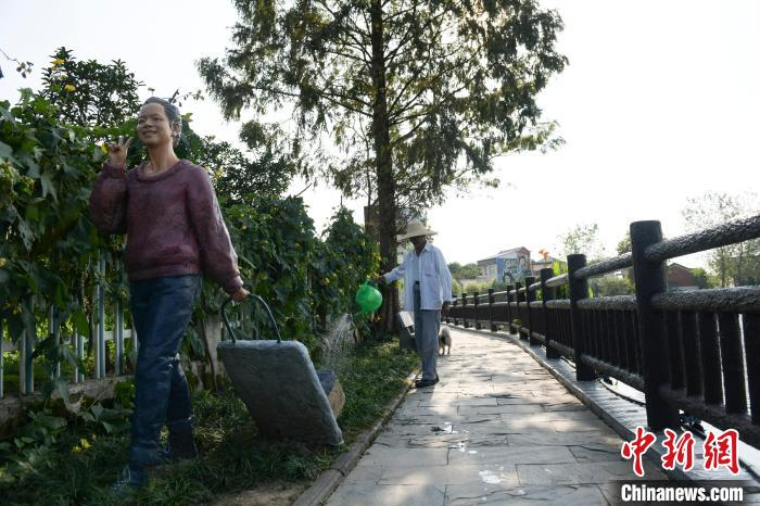 村民在给自家门前的绿植浇水。　张娅子 摄