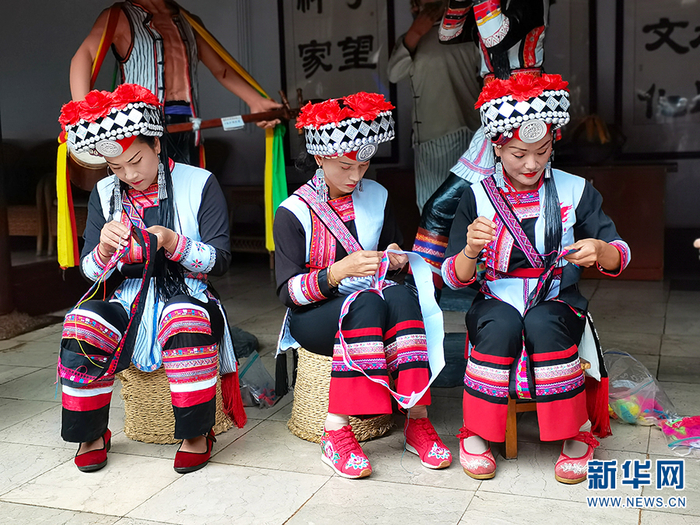 红河弥勒可邑小镇“阿细跳月”非遗传习点，身着传统民族服装的村民们正在进行刺绣（7月23日摄）。新华网 冯雨钐 摄