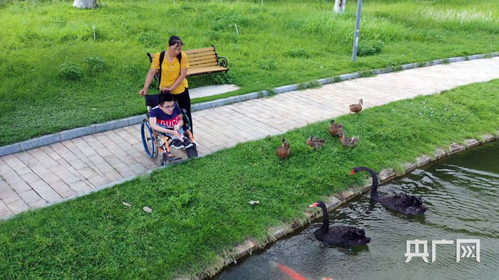 母亲推着曾廣在校园里散步（央广网记者 黄璐璐摄）