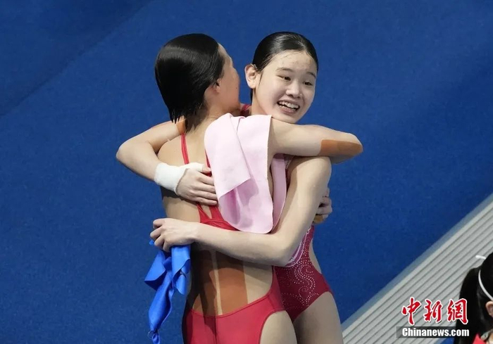 资料图：7月27日，中国跳水小将陈芋汐和张家齐，以363.78分成功夺得东京奥运会女子双人10米跳台冠军。图为比赛结束时陈芋汐和张家齐庆祝夺金。图片来源：视觉中国