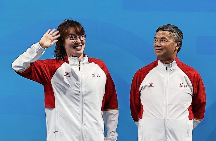 傅园慧和朱志根教练登上领奖台。