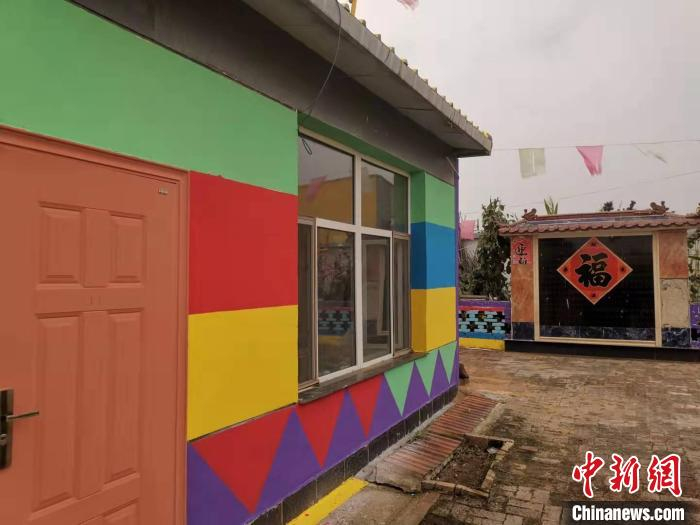 图为村民把自己的房屋也涂成了五颜六色。　乌娅娜 摄