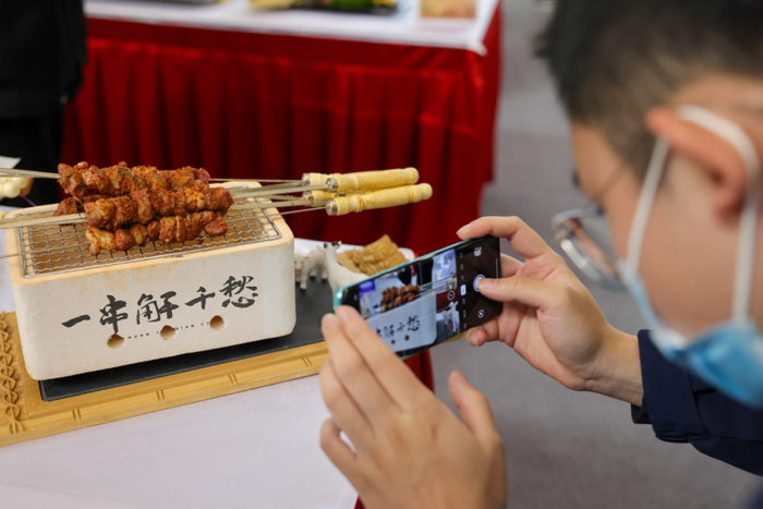　　9月27日，新疆国际会展中心。正在举办的全国乡村振兴职业技能大赛上，参赛选手的烤羊肉串作品吸引了观众驻足拍摄。&nbsp;新华社记者&nbsp;丁磊&nbsp;摄