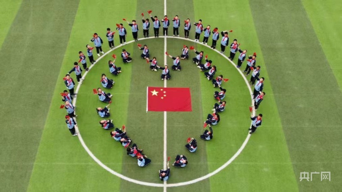 西宁市城东区十里铺小学学生与国旗合影（央广网发西宁市城东区委宣传部供图）