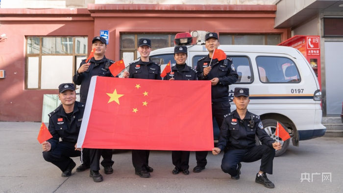 西宁市城东区林家崖派出所民警与国旗合影 （央广网发 西宁市城东区委宣传部供图）