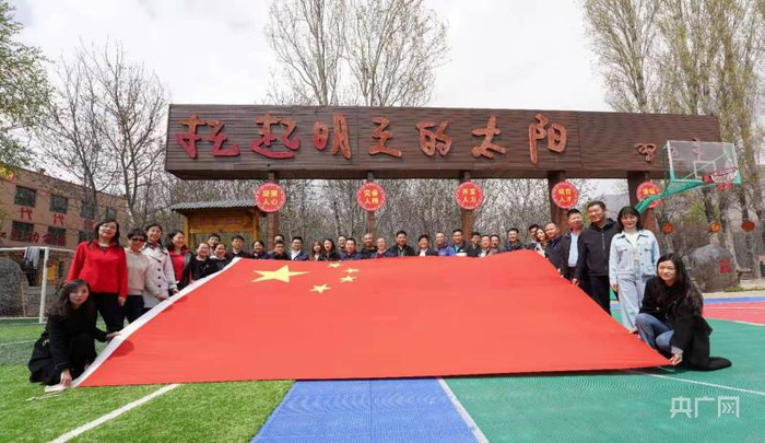 青海省海东市化隆县红光村和0118号国旗合影留念，聆听天安门国旗护卫队捐赠0118号国旗故事 。（央广网发 王伟才 摄）