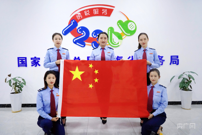 国家税务总局青海省税务局12366纳税服务中心工作人员与国旗合影，送上最美祝福 。（央广网发 任艳萍 摄）