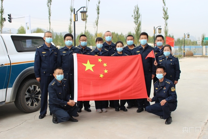 青海省民小高等级公路路政执法大队工作人员与国旗合影（央广网发 李奇 摄）