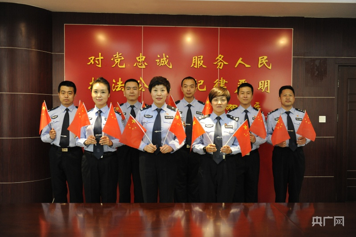 西宁市公安局城东公安分局民警与国旗合影（央广网发 肖文君 摄）