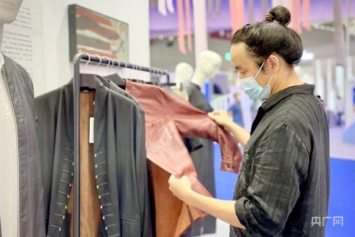 王伯杨在挑选心仪的香云纱服装。（央广网发 陈晖摄）