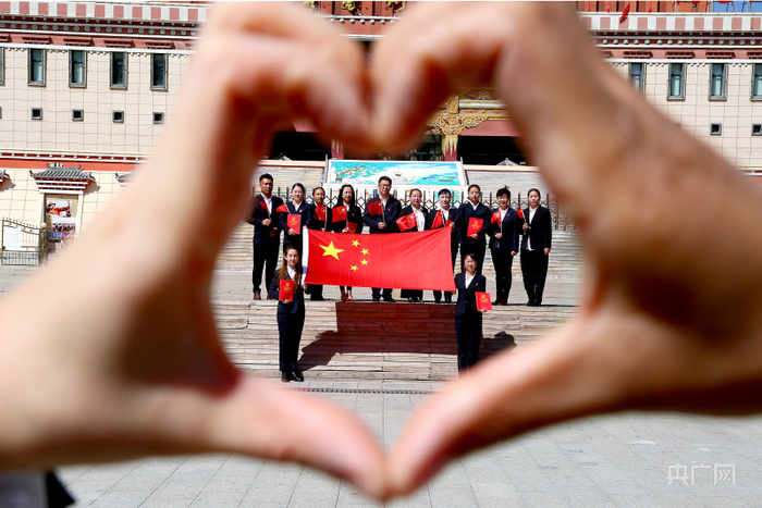 黄南藏族自治州同仁市司法局职工与国旗合影（央广网发 辛萃云摄）