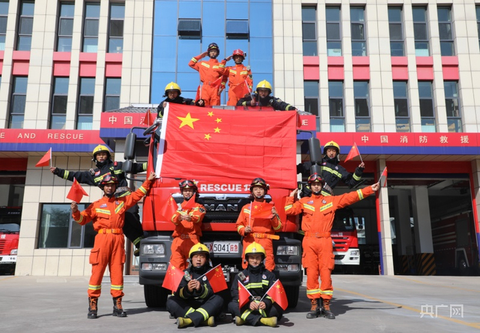 西宁市城东消防救援大队消防员与国旗合影（央广网发 西宁市城东区委宣传部供图）