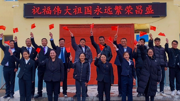 青海省果洛藏族自治州玛沁县东倾沟乡的乡镇干部们手执国旗，抒发心中最美的祝福，一致表示要不忘初心、砥砺前行，把对党、对祖国、对家乡的满腔热爱，转化为乡村振兴工作的强大动力。（央广网发 索南才让摄）