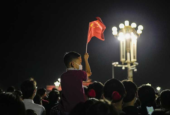 ▲10月1日5时17分，天安门广场内，一位小朋友手中挥舞着小国旗，等待观看升旗仪式。资料图。新京报记者赵亢、王飞 摄 