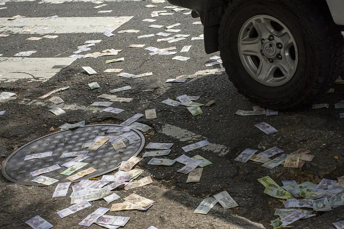 ▲因恶性通货膨胀贬值，玻利瓦尔(委内瑞拉货币)被扔一地。图源：视觉中国