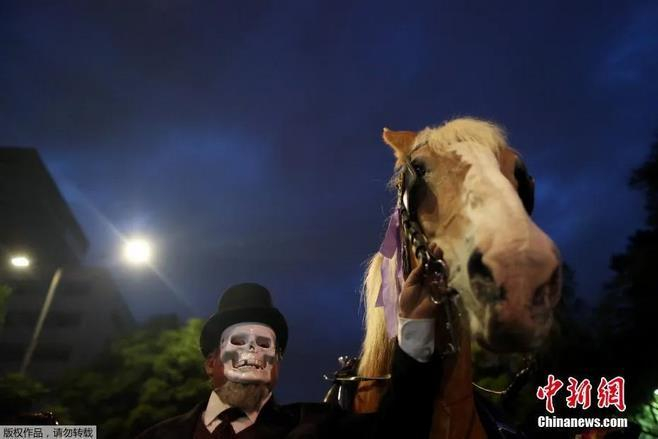 资料图：墨西哥庆祝“亡灵节”，民众举行神秘骷髅大巡游。