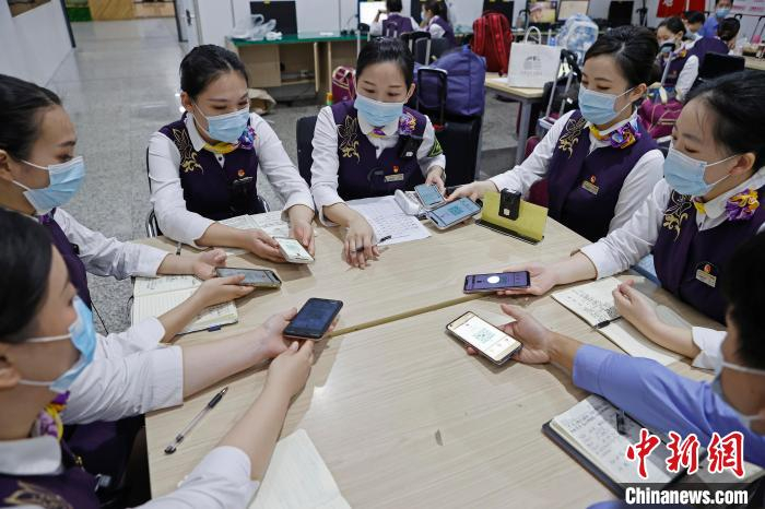 列车长李静芬正在对所有乘务员进行健康码检查。　殷立勤 摄