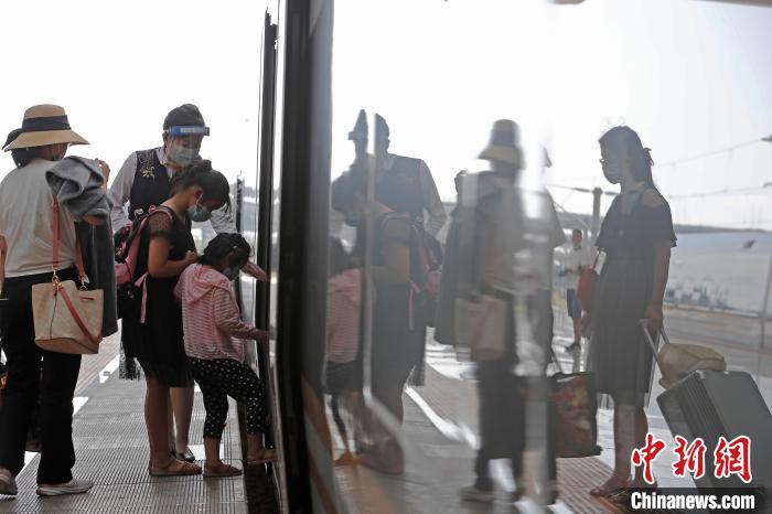 列车乘务员胡晶晶正在列车车门外迎接旅客的到来。　殷立勤 摄