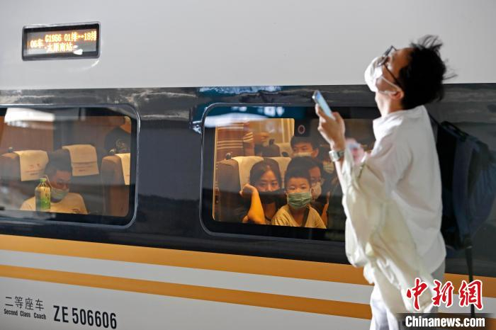 旅客与孩子一起戴着口罩在铁路上海虹桥站等待列车启动。　殷立勤 摄