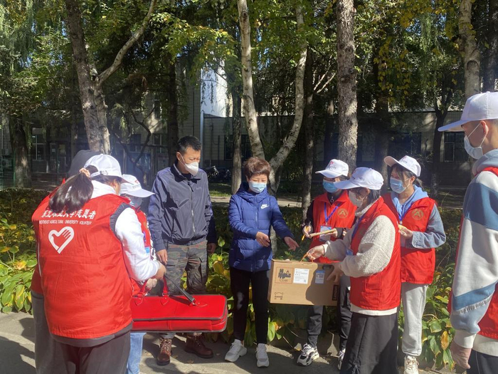 东北农业大学志愿者服务队为学生和家长传递物品。东北农业大学 供图