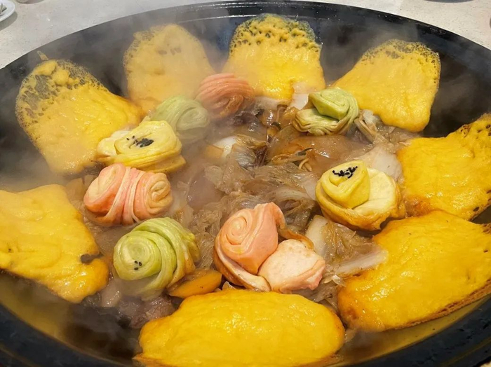 ▲ 在东北，铁锅炖里的食材能换，锅边的玉米饼不能换。摄影/韩小涵，图/图虫·创意