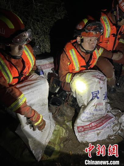短暂修整期间，消防员脱掉鞋袜，用编织袋套住腿脚保暖。　闫旭辉 摄