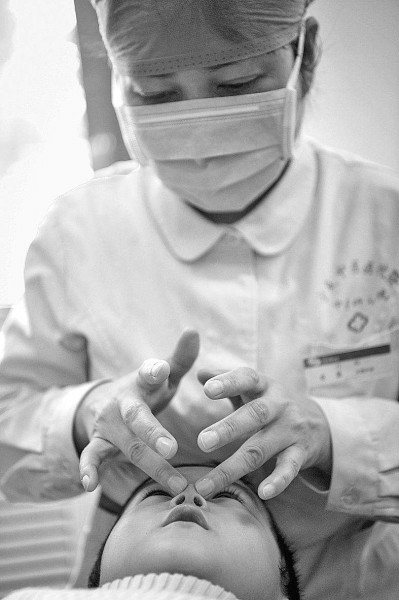 宁夏中医医院暨中医研究院的一名护师在为患儿推拿。新华社发