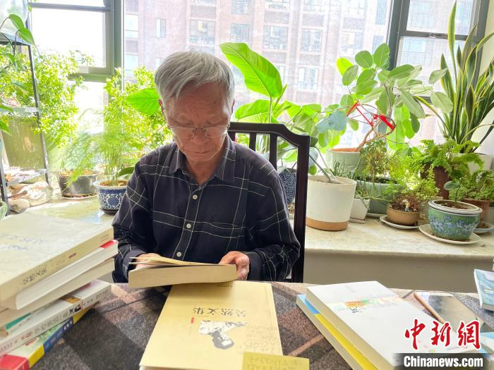 作家吴然向记者介绍创作经历。　刘丽慧 摄