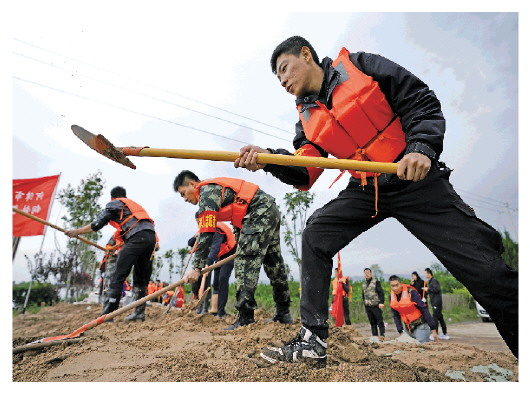 10月10日，抢险人员在连伯村加固临时堤坝。新华社记者 詹彦 图