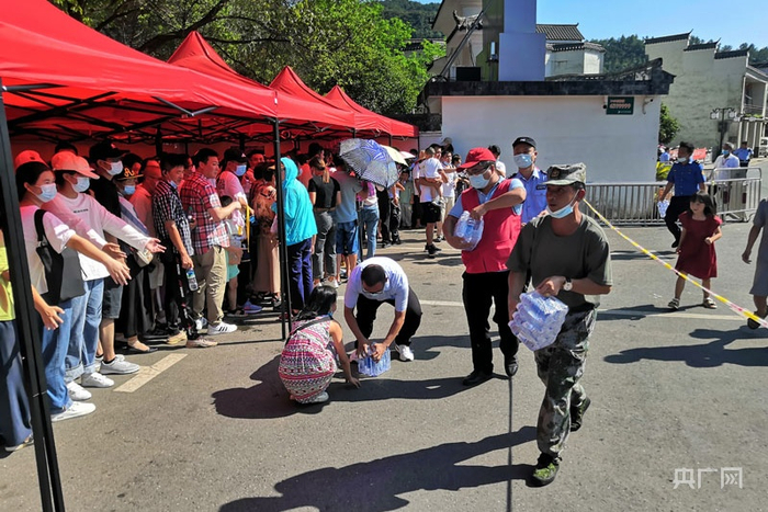 工作人员为排队等候的旅客免费发放冰镇矿泉水 （央广网发 罗家凡 摄）