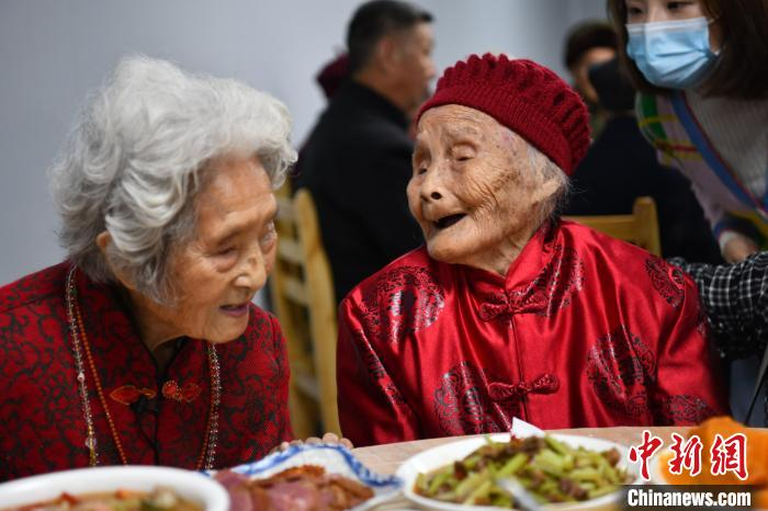 121岁的朱郑氏与喻泽琴话家常。张浪摄