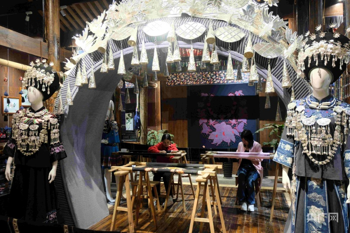 铜仁中南门古城内游客体验苗绣（央广网发 张翼晶 摄）