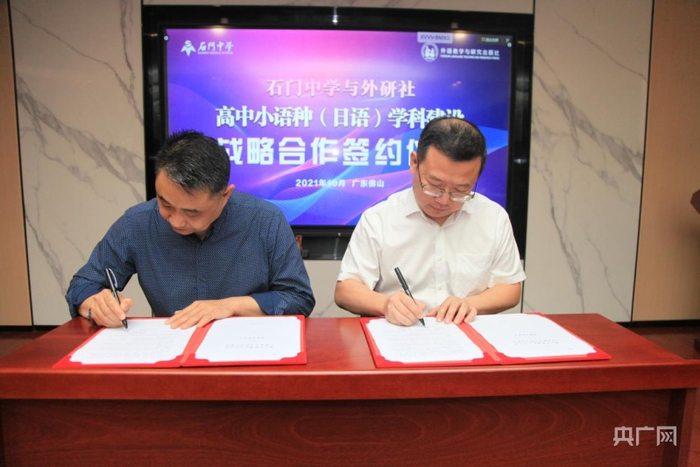 外研社代表涂宜将副总裁和石门中学代表徐庆均副校长共同签署协议书（佛山石门中学供图 央广网发）