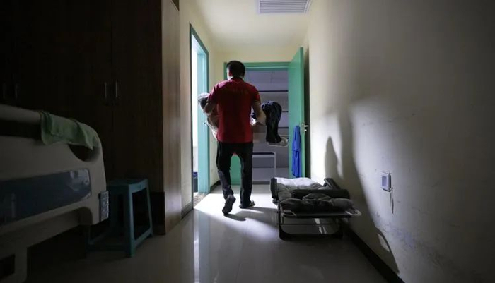 ▲赵晓波每隔2个小时把母亲抱到卫生间的马桶上方便。
