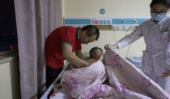 ▲如果发现有老人发热等症状，赵晓波就会把值班医生和护士叫来，为老人检查。