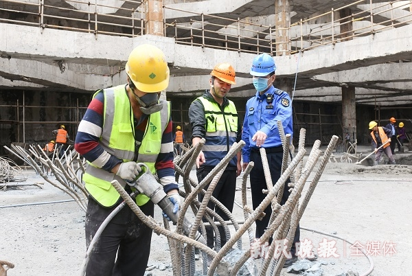 图说：城管执法队员在娄山关路440弄小区对面工地现场检查 新民晚报记者 陶磊 摄