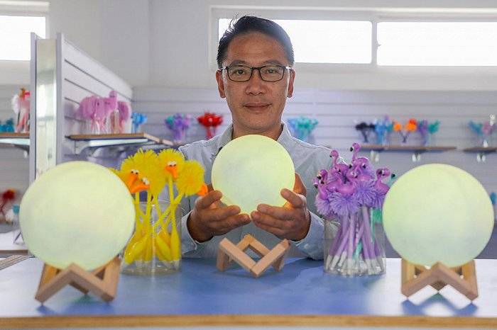 盛汉伟展示企业生产的月球灯产品。（受访者供图）