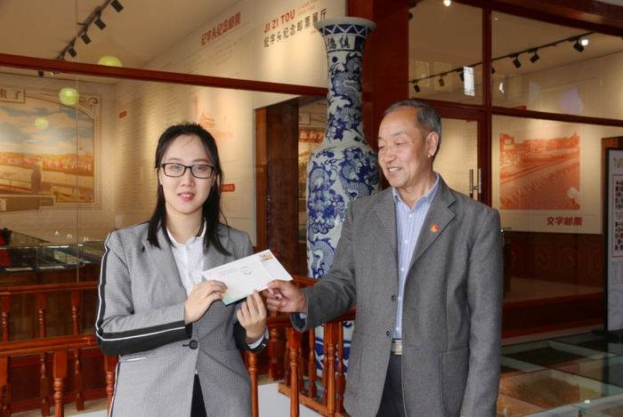 （游客在购买鸡鸣驿特色纪念封及明信片，打卡留念，企业供图，央广网发）