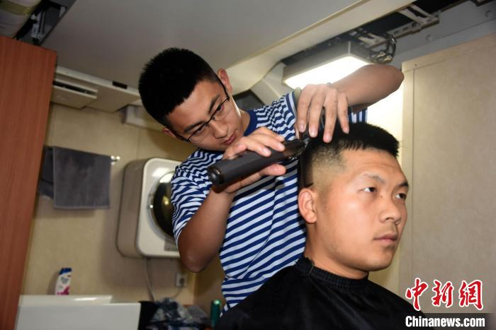 南昌舰官兵兼职理发师为战友理发。　中新社记者 孙自法 摄