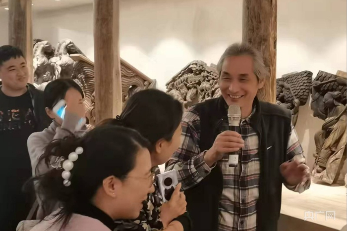中国文物学会会员翁鹤亮正在给游客进行讲解（央广网发 童嘉颖摄）