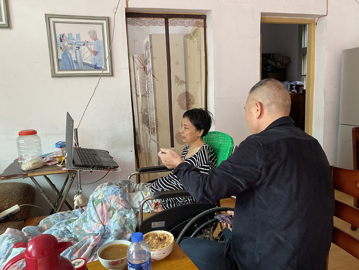  谌石军在给李小中喂饭。