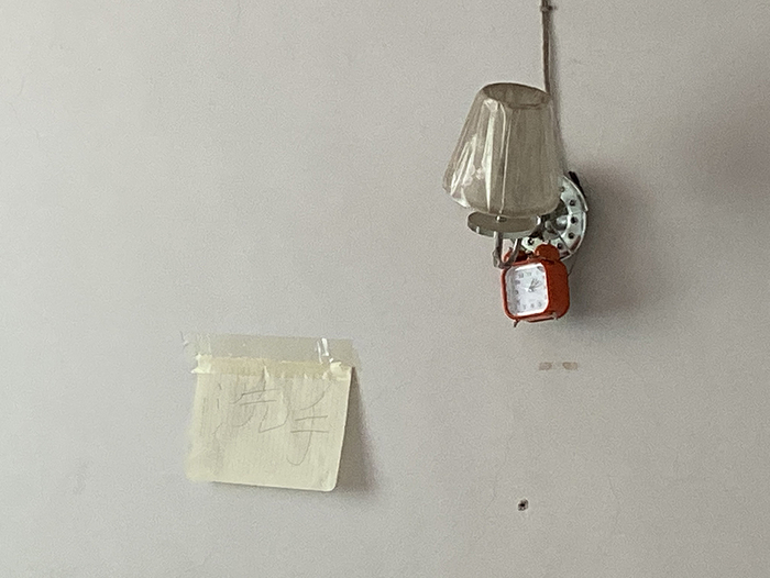  李小中的床头贴着“洗手”二字，提醒保姆注意卫生。