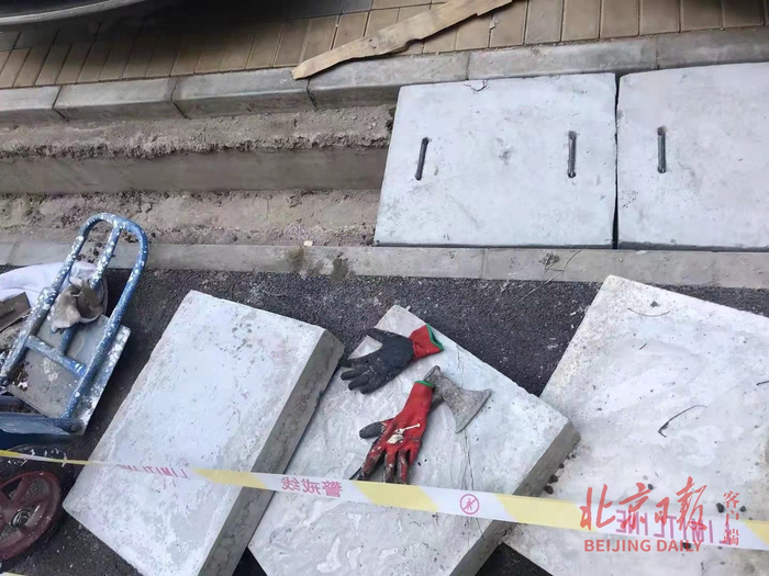 老旧小区改造中，道路两侧水沟上新铺的青石盖板扒掉后再换新。